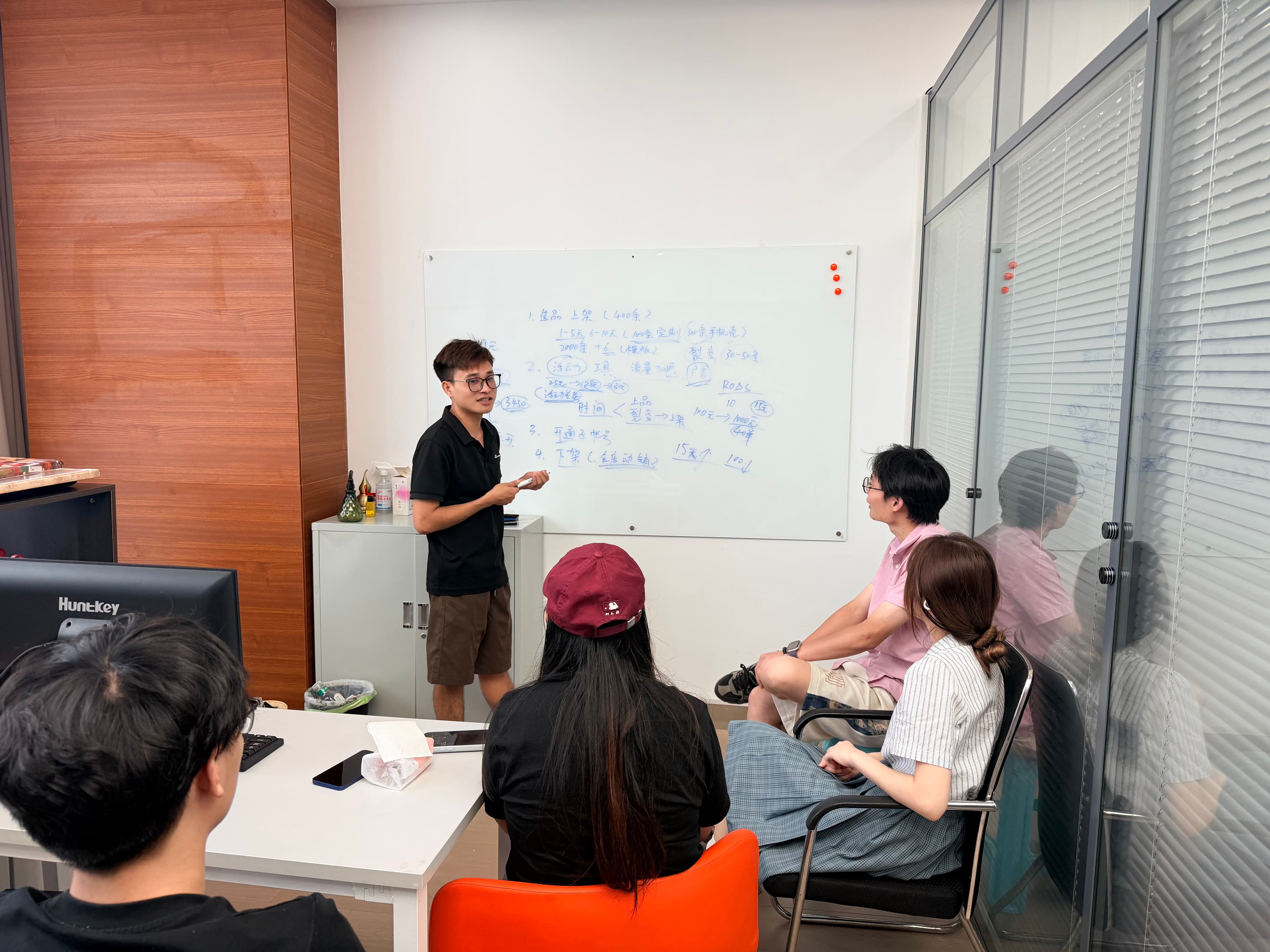 PODJST team discussing a product plan around a whiteboard